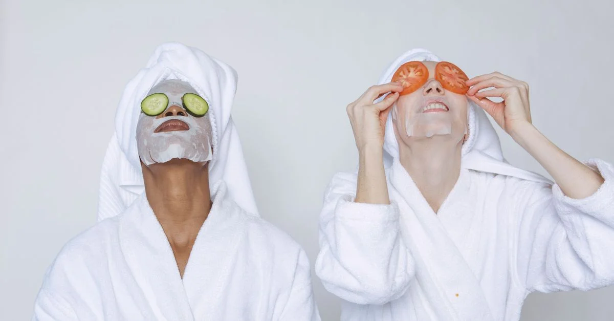 Deux femmes profitant d'un soin facial avec des concombres et des tomates à l'intérieur.