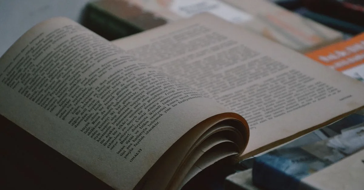 Un gros plan d'un livre ouvert avec du texte et des pages visibles, capturé dans une ambiance intérieure confortable.